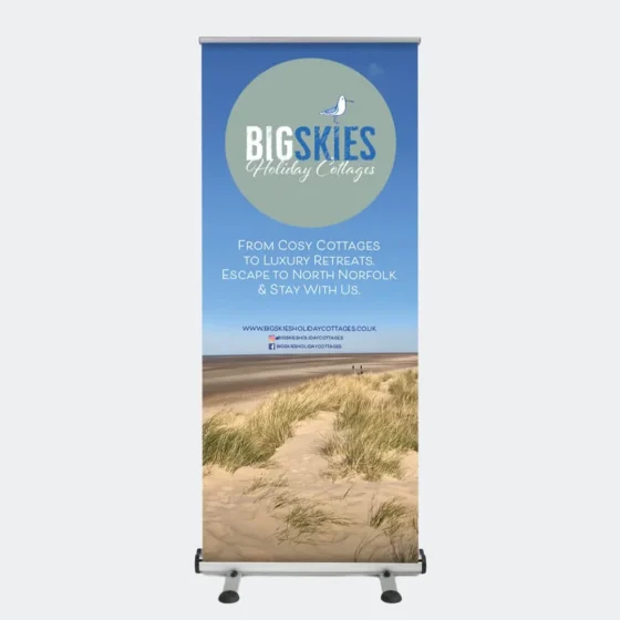 an outdoor roller banner with an image of the beach and blue skies