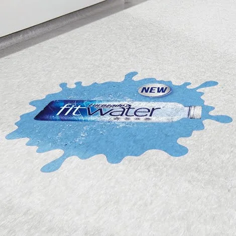 Indoor Advertising Floor Decal: Bright and eye-catching floor decal placed inside a retail store to advertise a new product launch, printed on high-quality vinyl with a sticky, removable adhesive for easy application and removal.